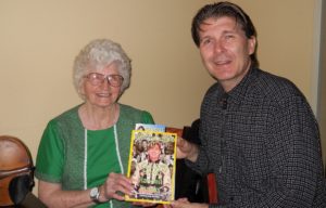 Randall Franks shares his new â€œEncouragers III: A Guiding Handâ€ with centenarian Violet Hensley when the American folk legend recently debuted as a Grand Ole Opry guest star. Hensley is seen in the book's Moments in Time section and will mark 50 years performing at Silver Dollar City in Branson, Mo. this fall. (Photo: Randall Franks Media/Sandra Flagg)